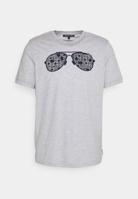 Camiseta de algodón gris con un diseño azul marino de gafas de sol grandes y texto que detalla el nombre de la marca y el estilo. Mangas cortas, cuello redondo.