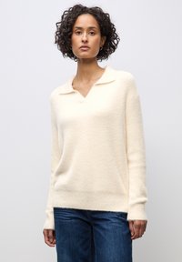 Maglione color crema con scollatura a V e colletto, realizzato in un materiale morbido e testurizzato, con maniche lunghe e una vestibilità rilassata.
