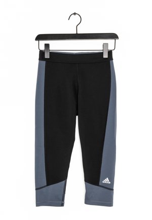 Černé sportovní legíny s modrými bočními panely, přiléhavým střihem a prošitými detaily. U lemu je logo Adidas.