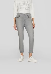 Gray jeans with a slim fit, featuring four pockets and a zip fly. Worn with a white textured top and white sneakers.