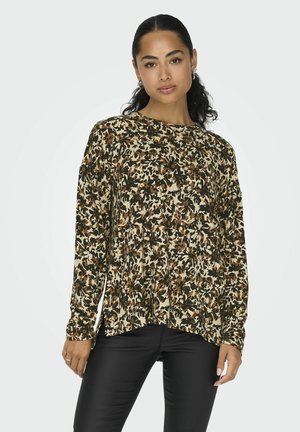 Langarmshirt in een beige, bruine en groene bloemenprint, gemaakt van zachte stof. Rond afgewerkt onderaan en aangesloten manchetten. Gecombineerd met zwarte broek.