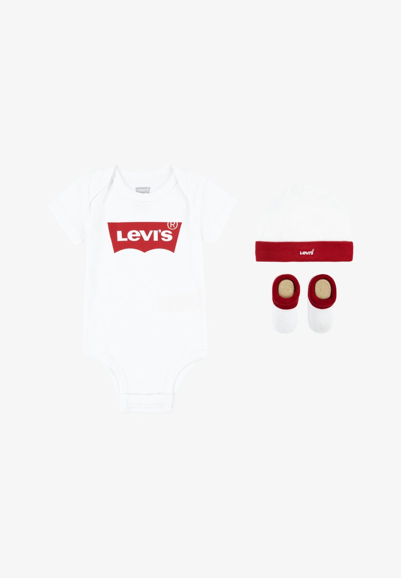 Weißer Baumwollstrampler mit rotem Levi's-Logo, dazu ein weißer Hut mit rotem Band und passende rot-weiße Booties.
