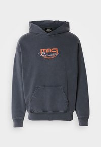 Sudadera gris oscuro con un bolsillo frontal, capucha con cordón y un logo gráfico en naranja "mmg Paradise Disco Dancing Club" en el pecho. Tejido de mezcla de algodón.