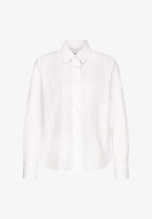 Hvid langærmet skjorte med knapper foran, spids krave og diskrete lodrette blonder-lignende mønstre på front og ærmer.