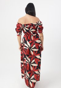 Maxi kjole med blomsterprint i rød, creme og sort. Off-the-shoulder design med puffede ærmer og smocket bodice.