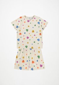 Set in cotone beige a maniche corte composto da T-shirt e pantaloni shorts con un motivo di cuori multicolori e faccine sorridenti. Vestibilità rilassata, vita elastica.