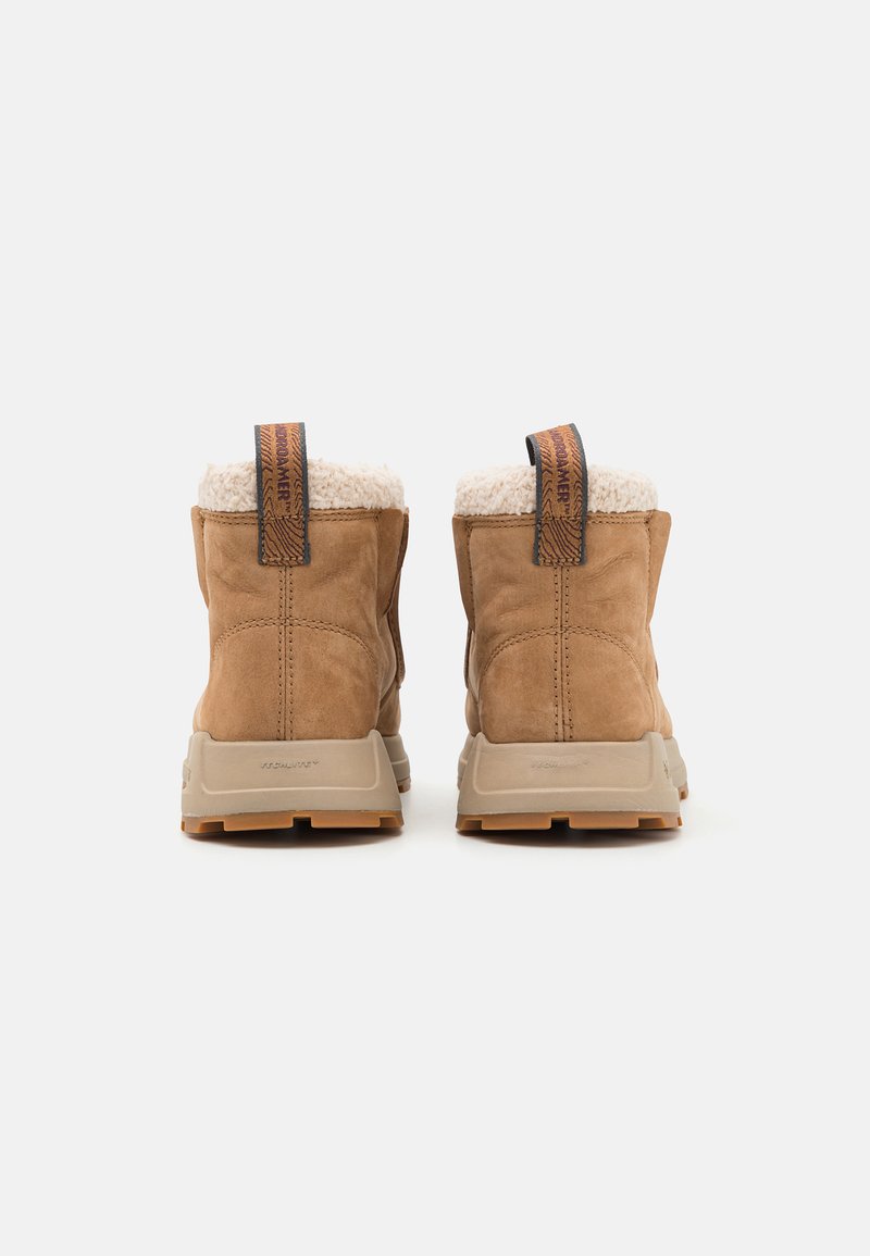 Botas de invierno marrones con parte superior de ante y forro de felpa suave. Cuenta con una suela de goma resistente y un tirador para ponérselas fácilmente.