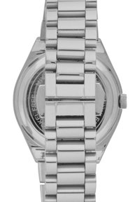 Montre-bracelet en acier inoxydable argenté avec un boîtier octagonal, un bracelet à maillons en métal et un cadran rond simple visible à travers un fond transparent.