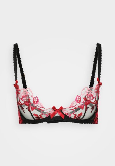 Soutien-gorge noir en dentelle avec broderies florales rouges, présentant un matériau transparent, des bretelles ajustables et des nœuds décoratifs rouges. Design élégant qui met en valeur les détails.