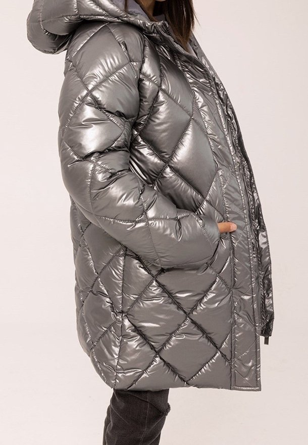Doudoune argentée avec capuche, présentant un design matelassé et une finition brillante. Comprend des poches latérales et une fermeture éclair frontale complète.