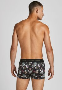 Schwarze Boxerbriefs mit floralem Muster und deast schwarz elastischem Bund, der das goldene Logo "JACK & JONES" trägt. Weicher Stoff und eng anliegende Passform.