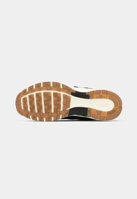 Sole boty Nike v černé barvě a gumovém kaučuku, s vzorovaným trakčním povrchem, bílou mezipodešví a raženým logem.