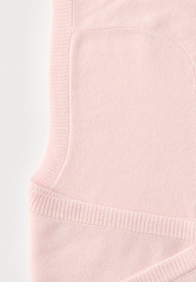Svetloružová tkanina s jemnou textúrou. Má rebrovaný pletený pás a bočnú kapsu. Hladký povrch s miernym elastickým efektom.