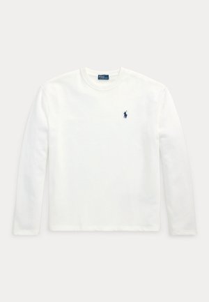 Hvit langermet t-skjorte laget av bomull, med ribbet rund hals og liten marineblå logo på venstre bryst. Glatt tekstur, enkelt design.