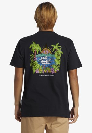 Personne aux cheveux châtain clair vue de dos portant un T-shirt noir avec un imprimé tropical coloré et un texte au dos.
