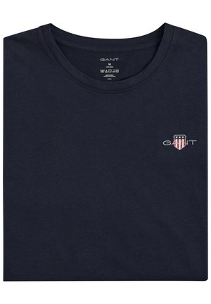 Mörkblå bomullströja med rund halsringning. Har en liten broderad logotyp på bröstet. Mjuk textur och klassisk design.