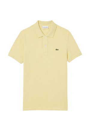 Vaaleankeltainen polo-paita pehmeästä, tekstuurilla varustetusta kankaasta. Huomattava vihreä Lacoste-logo rinnassa, klassinen kaulus ja kolmesta napista koostuva vetoketju.