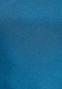 Geripptes blaues Stoffmaterial mit glatter Textur, das vertikale Streifen und ein figurbetontes Design aufweist, geeignet für legere oder geschichtete Kleidung.