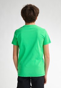 Groene katoenen t-shirt met ronde hals en korte mouwen, met een gladde textuur en een relaxte pasvorm, gezien van achteren.