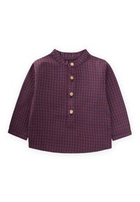 Camicia a quadri rossi e blu con colletto a bandiera, maniche lunghe e cinque bottoni in legno sul davanti. Tessuto morbido con una finitura texture.