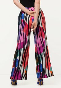 Pantaloni a gamba larga colorati con un audace motivo di strisce e forme circolari in rosso, viola, blu e nero, con una vita elastica.