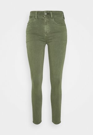 Vaqueros ajustados en verde oliva, con una cintura alta, diseño de cinco bolsillos, cierre mediante cremallera y detalle con botón de metal. Tejido suave y elástico.