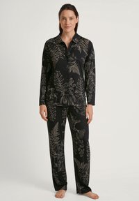 Zwart pyjama set met een lange mouw knoop-overhemd en broek, versierd met ingewikkelde lichtgekleurde bloemen- en varenpatronen. Zachte stofstructuur.