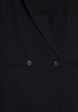 Blazer noir à rayures avec larges revers, design double boutonnage, deux boutons et deux poches frontales horizontales.