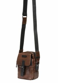 Brązowa skórzana torebka na ramię z zamkiem błyskawicznym, regulowanym paskiem, przednim klapą i czarnymi akcentami. Kompaktowy design, teksturowana powierzchnia.