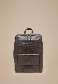 Sötétbarna hátizsák krokodilbőr textúrával, felül hordozófüllel, elején zsebbel és dupla cipzárral. Kompakt, téglalap alakú forma.