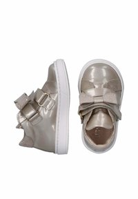 Scarpe in pelle sintetica beige con cinturini in Velcro e fiocchi decorativi, dotate di suola in gomma bianca e morbida fodera interna.