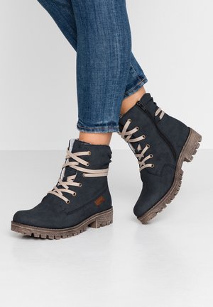 Donkerblauwe enkellaarsjes met beige veters, textuur leer, ritsluiting en een robuuste bruine zool, met een klein logo accente.