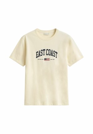 Cremefarbenes T-Shirt mit kurzen Ärmeln, mit dem Schriftzug "EAST COAST", einer kleinen amerikanischen Flagge und einem weiteren kleinen Aufdruck unter dem Text vorne.