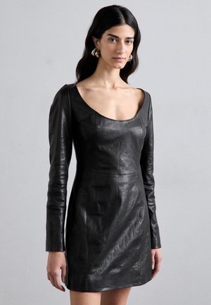 Black leather mini dress with a fitted silhouette, long sleeves, and a wide scoop neckline. Features a smooth texture and minimal stitching details.