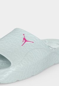 Λευκό σατινέ σανδάλι με ροζ λογότυπο Jumpman στο λουράκι, με διαμορφωμένη πάτο και σόλα.