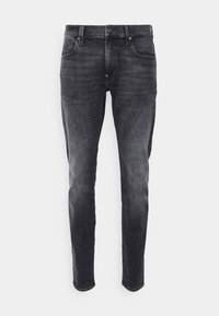 Jeans de denim negro con corte ajustado, que presentan un diseño de cinco bolsillos, un leve desvanecimiento y un cierre frontal de botón. Textura suave y peso medio.