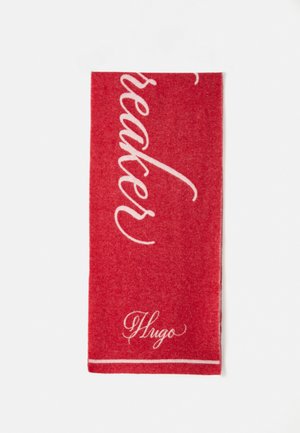 Serviette rouge avec un texte en cursive blanche qui dit "Breaker" avec un "Hugo" plus petit en bas, fabriquée en tissu doux avec une texture lisse.