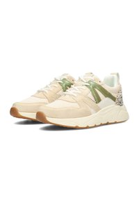 Zapatillas beige claro con acentos verdes, que cuentan con una mezcla de materiales de malla y ante, paneles laterales texturizados y cordones blancos. Suela de goma.