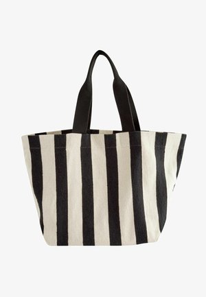 Gestreifte Tragetasche aus Canvas mit auffälligen schwarz-weißen Streifen, doppelten schwarzen Stoffgriffen und einer breiten Öffnung für die Aufbewahrung.