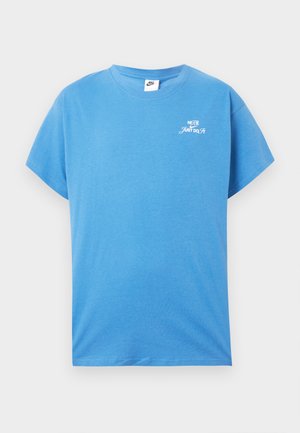 Zila kokvilnas T-krekls ar īsām piedurknēm, apaļu kakla izgriezumu un balto logo "Just Do It" uz krūtīm. Ritināta tekstūra, brīvs piegriezums, ikdienas dizains.