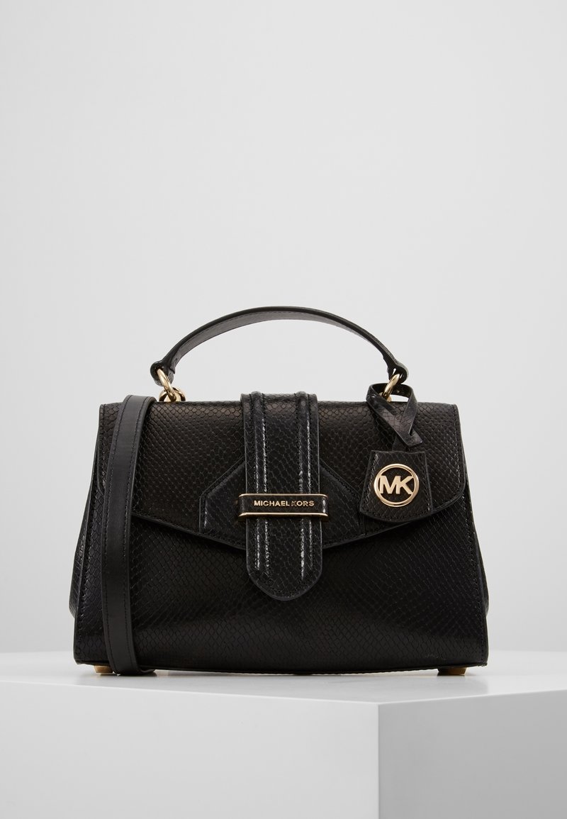 Svart handväska i texturerad läder med ett överhandtag och justerbar axelrem. Har guldpläterade detaljer och en logotypaccent.