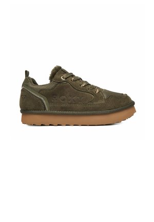 Zamszowy sneaker w kolorze oliwkowym z grubą beżową gumową podeszwą, plecionymi sznurowadłami i tłoczonym "ROXY" na bocznej części.