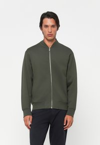 Oliven grøn zip-up sweatshirt med høj krave, ribbede cuffs og kant. Har et enkelt design og glat tekstur.
