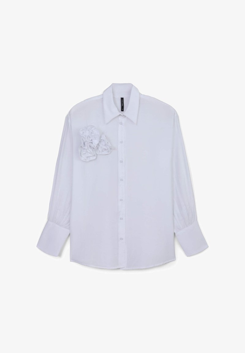 Camicia bianca a maniche lunghe con colletto strutturato, dettagli arricciati sul petto e polsini fitted. Finitura in tessuto liscia.