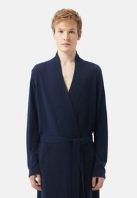 Marineblå badrock av mjukt tyg, med sjalkrage, långa ärmar, midjesnöre och två framfickor.
