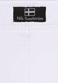 Weißer Stoff mit glatter Textur. Verfügt über ein schwarzes Etikett mit dem Namen "Nils Sundström" und einem kleinen grafischen finnischen Flaggenmotiv.