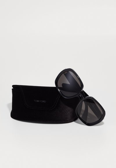 Črne kvadratne sončne očala s temnimi lečami, z debelim plastičnim okviru. V kompletu s črnim žametnim etuijem z logotipom "TOM FORD".