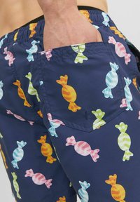 Pantaloni da bagno navy con un motivo a caramelle in vari colori, dotati di una tasca posteriore e di una vita elastica per il massimo comfort.