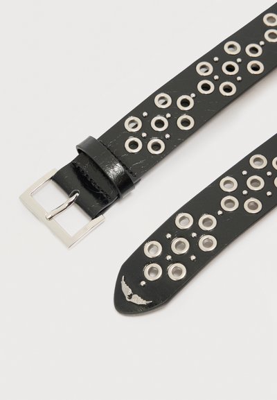 Μαύρη δερμάτινη ζώνη με ασημένια αγκράφα και πολλαπλές ασημένιες τρύπες σε μοτίβα, με ένα μικρό μεταλλικό στολίδι σε σχήμα φτερού.