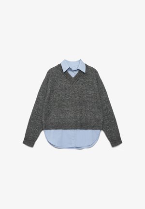 Grauer, gestrickter Pullover mit V-Ausschnitt und cropped Passform, der lange Ärmel hat. Darunter ein hellblaues Hemd mit Kragen und abgerundetem Saum.